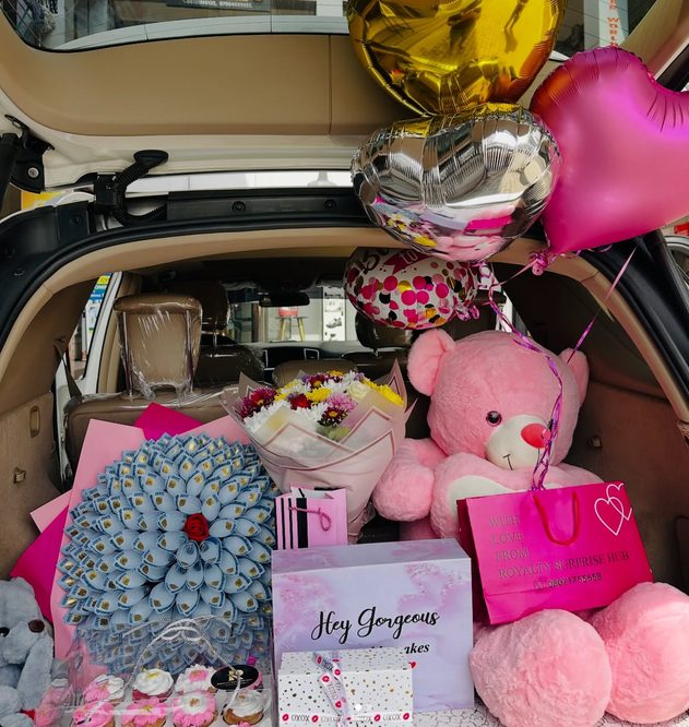Car trunk filled with teddy bears balloons and flowers gift delivery